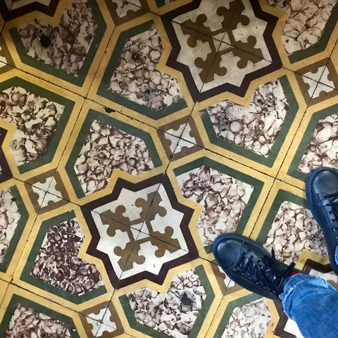 Navy sneakers on antique patterned cement tiles