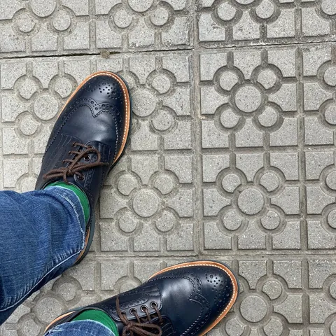 Navy brogues on Barcelona's flower-pattern pavement tiles