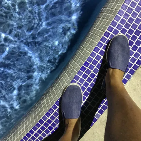 Blue espadrilles on a cobalt mosaic pool edge