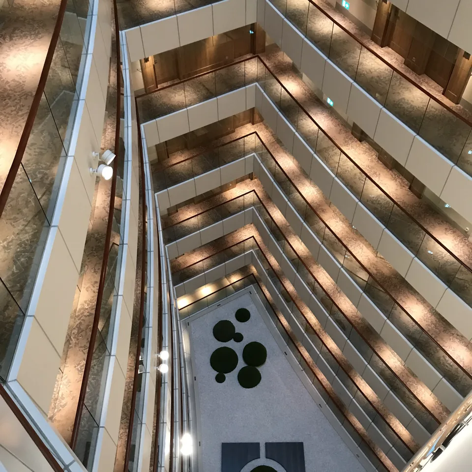 An atrium seen from above, its balconies stepping down in bands of light