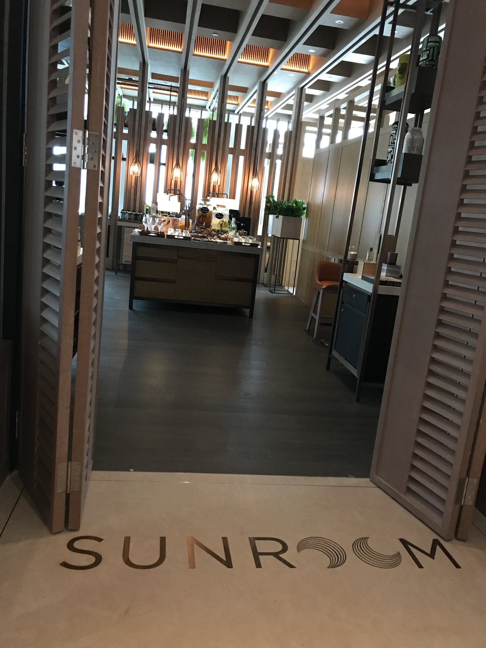 An open doorway with SUNROOM inlaid in the floor, a counter visible beyond