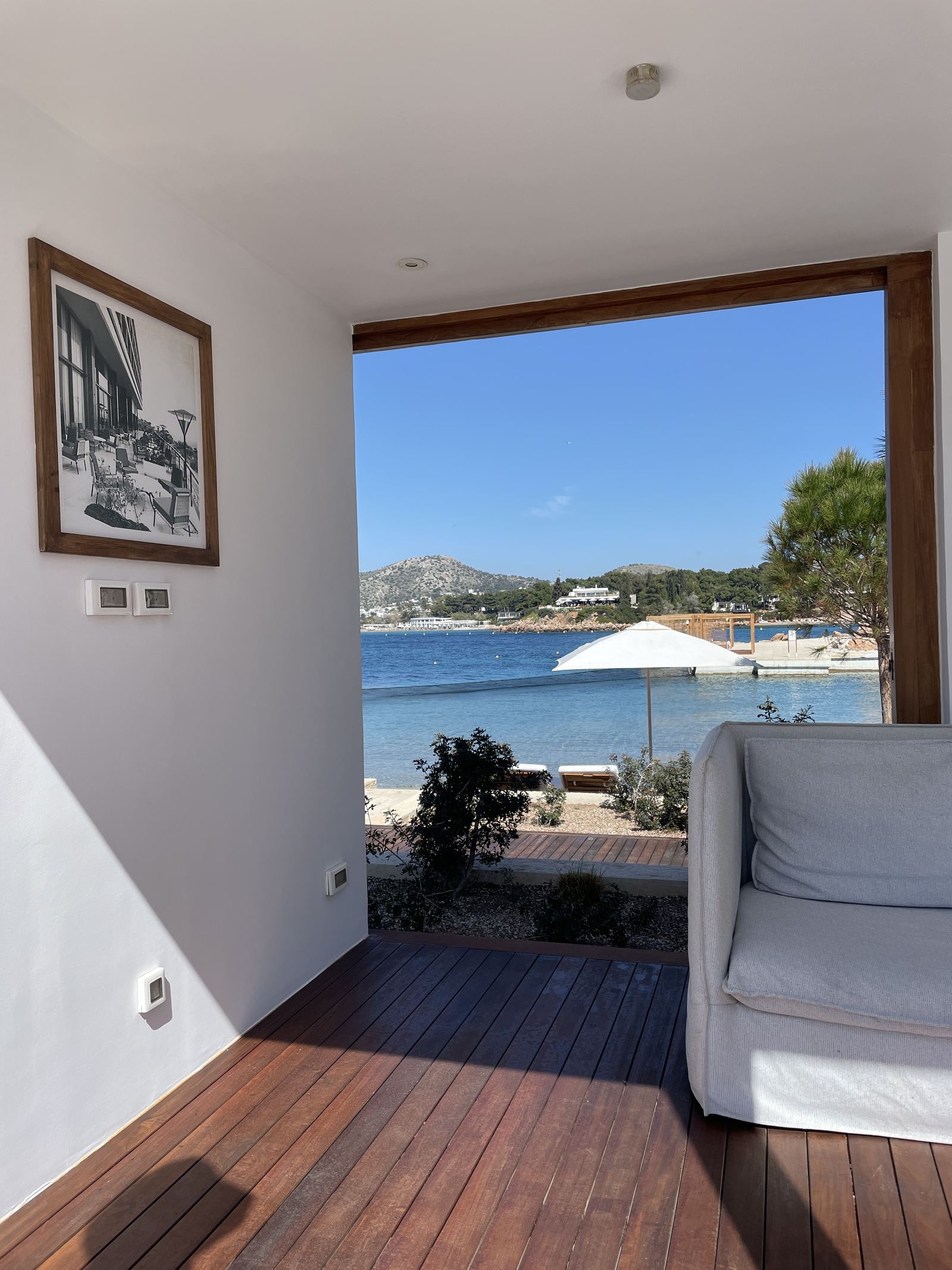The interior of a bungalow looking out to the beach through open glazing