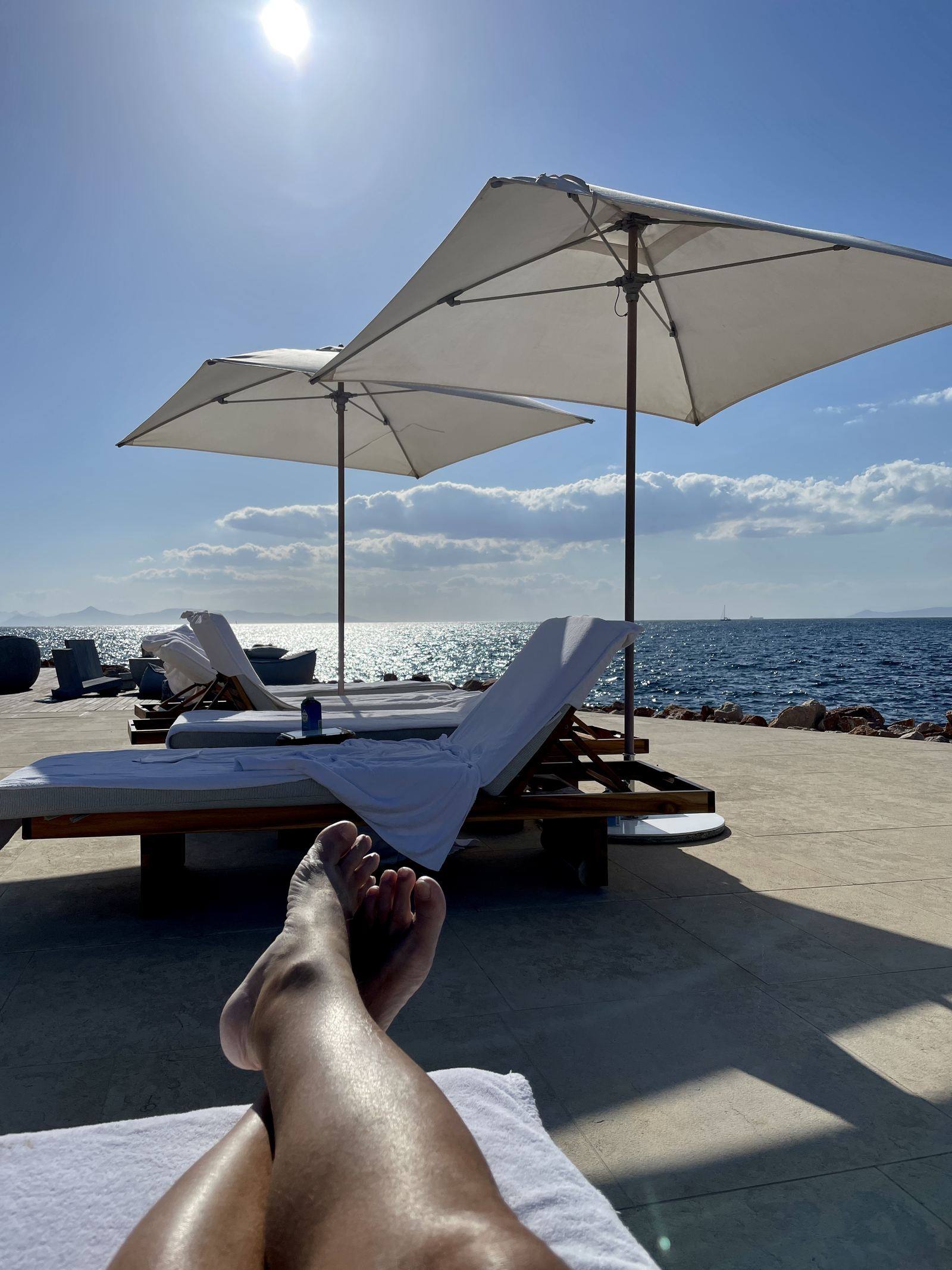 Two parasols and a lounger at the water's edge