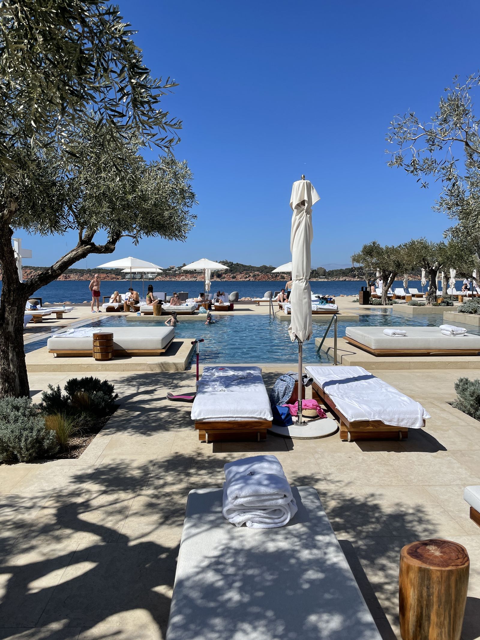 The pool at Four Seasons Astir Palace among olive trees, the beach beyond