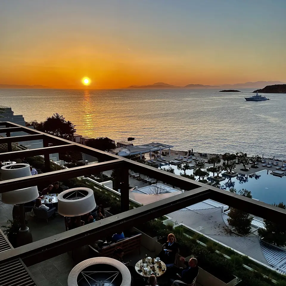 The terraces and the pool at Four Seasons Astir Palace seen from above at sunset