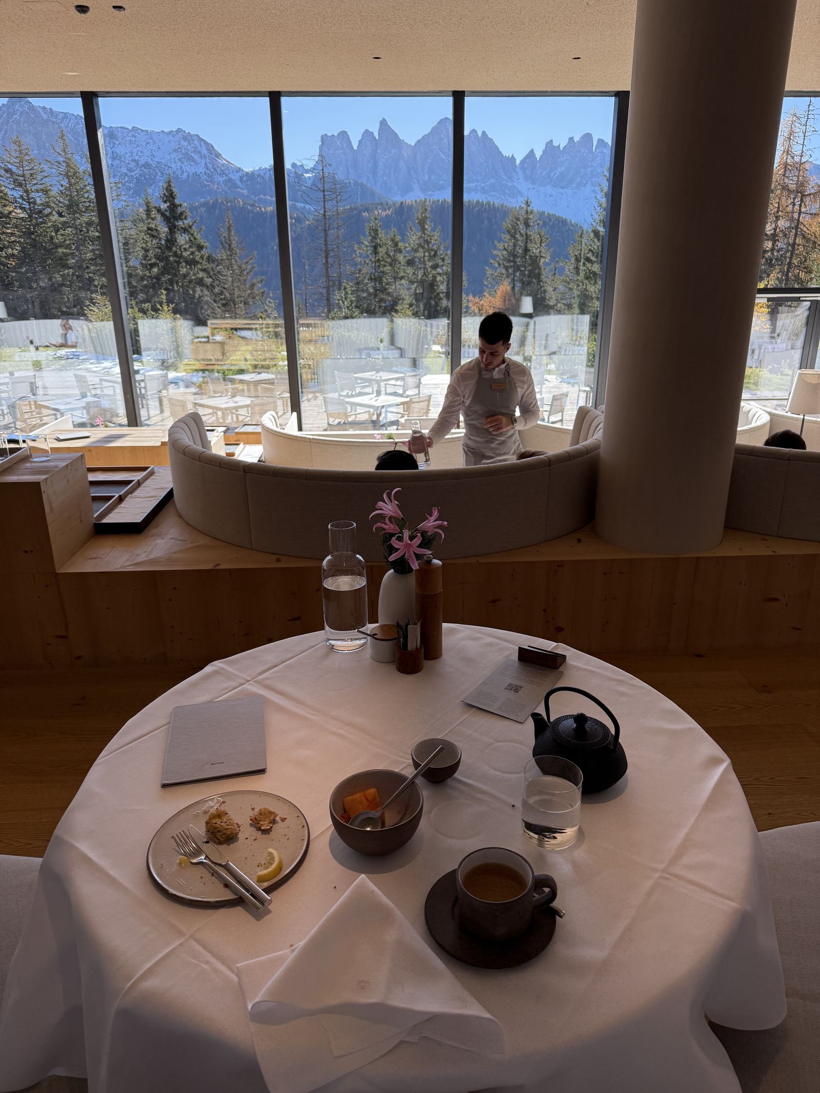 A breakfast table at FORESTIS with the Odle framed by the dining room glazing