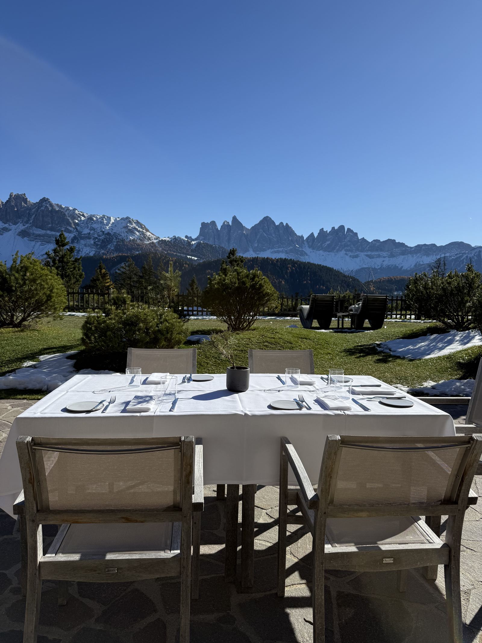 A table laid for lunch on the lawn at FORESTIS facing the Odle
