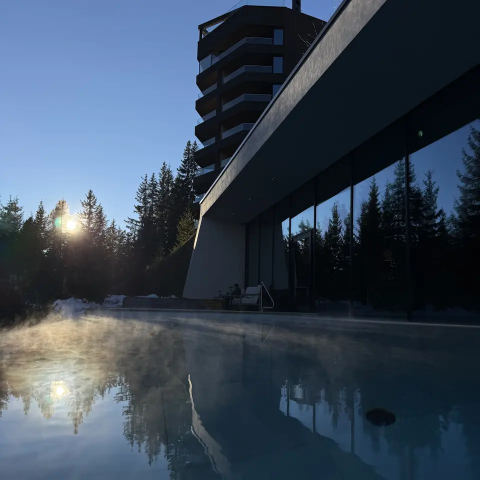 Steam rising from the outdoor pool at FORESTIS at dusk