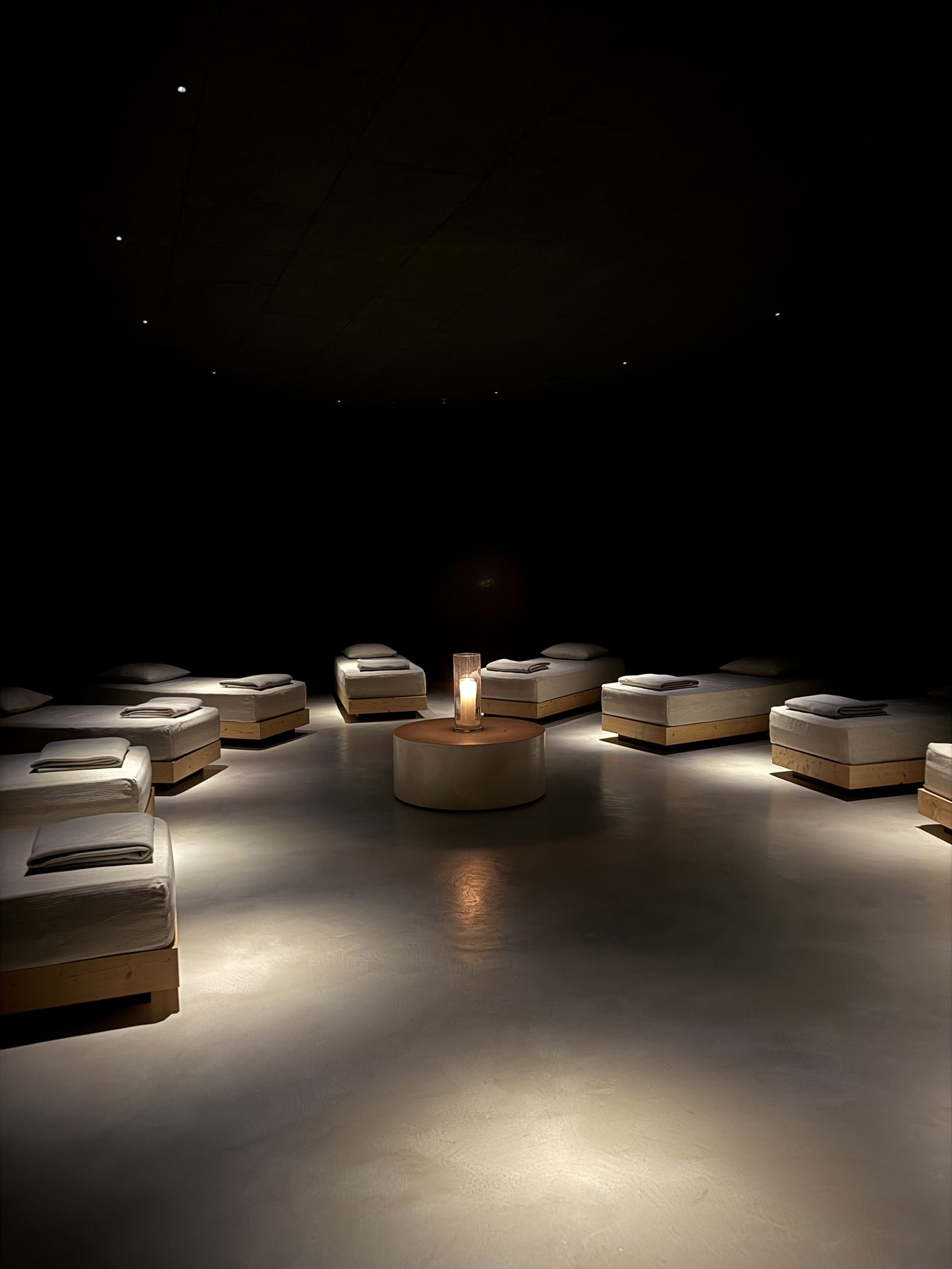 The darkened relaxation room at FORESTIS lit by a single candle