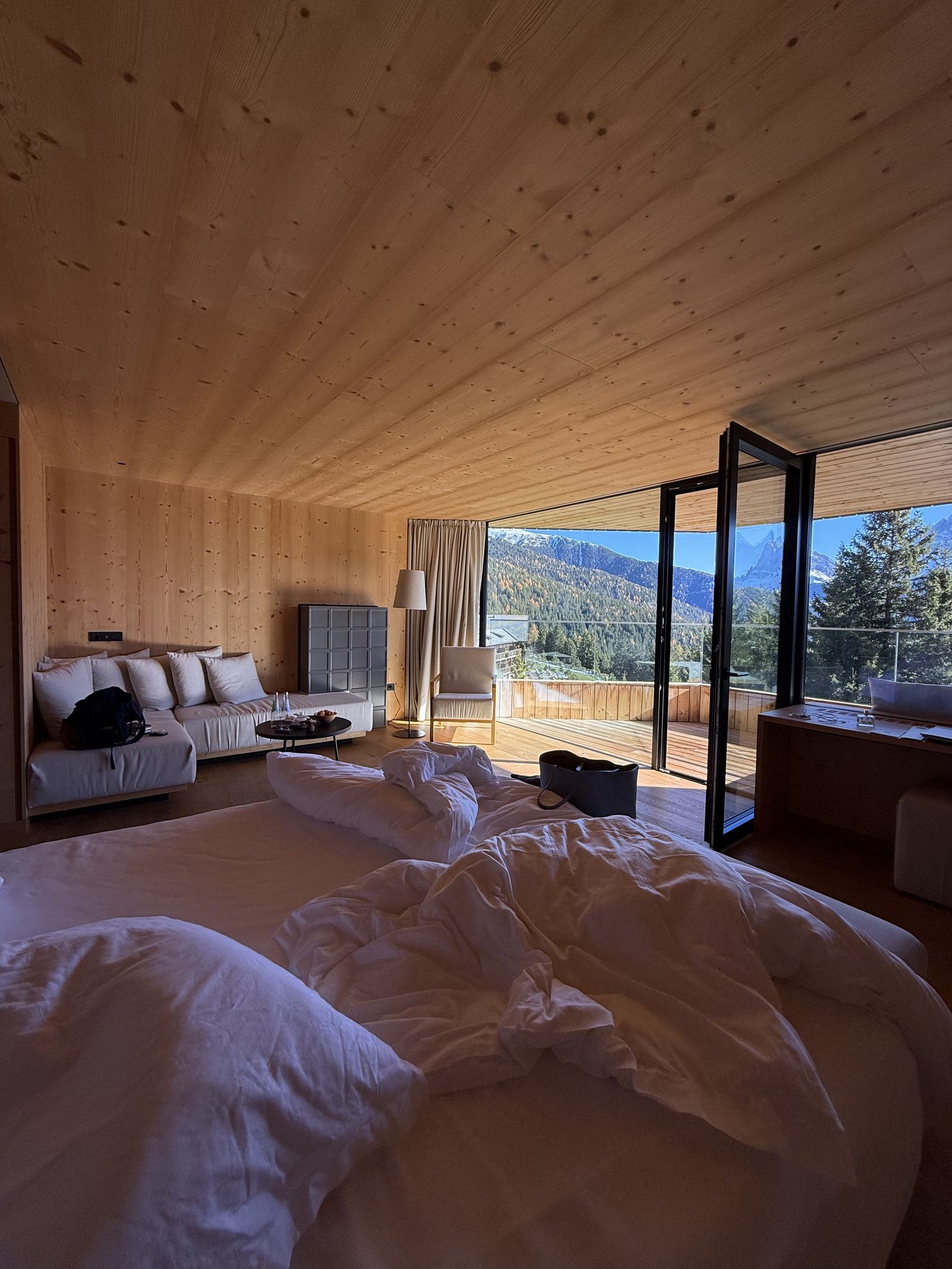 An unmade bed in a suite at FORESTIS in late afternoon light