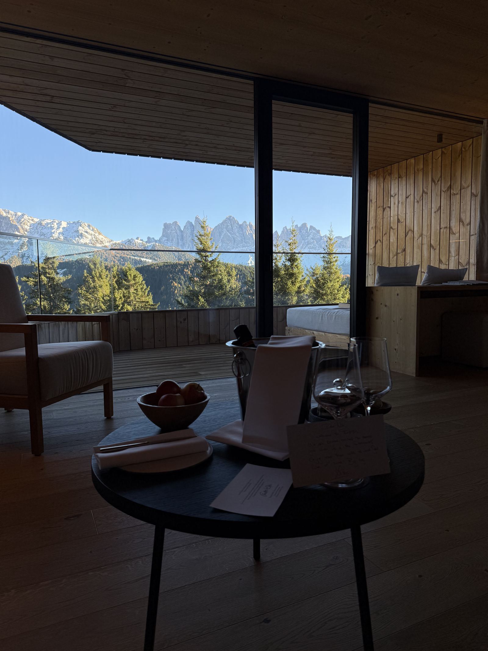 A welcome tray with fruit and sparkling wine on a table facing the mountains
