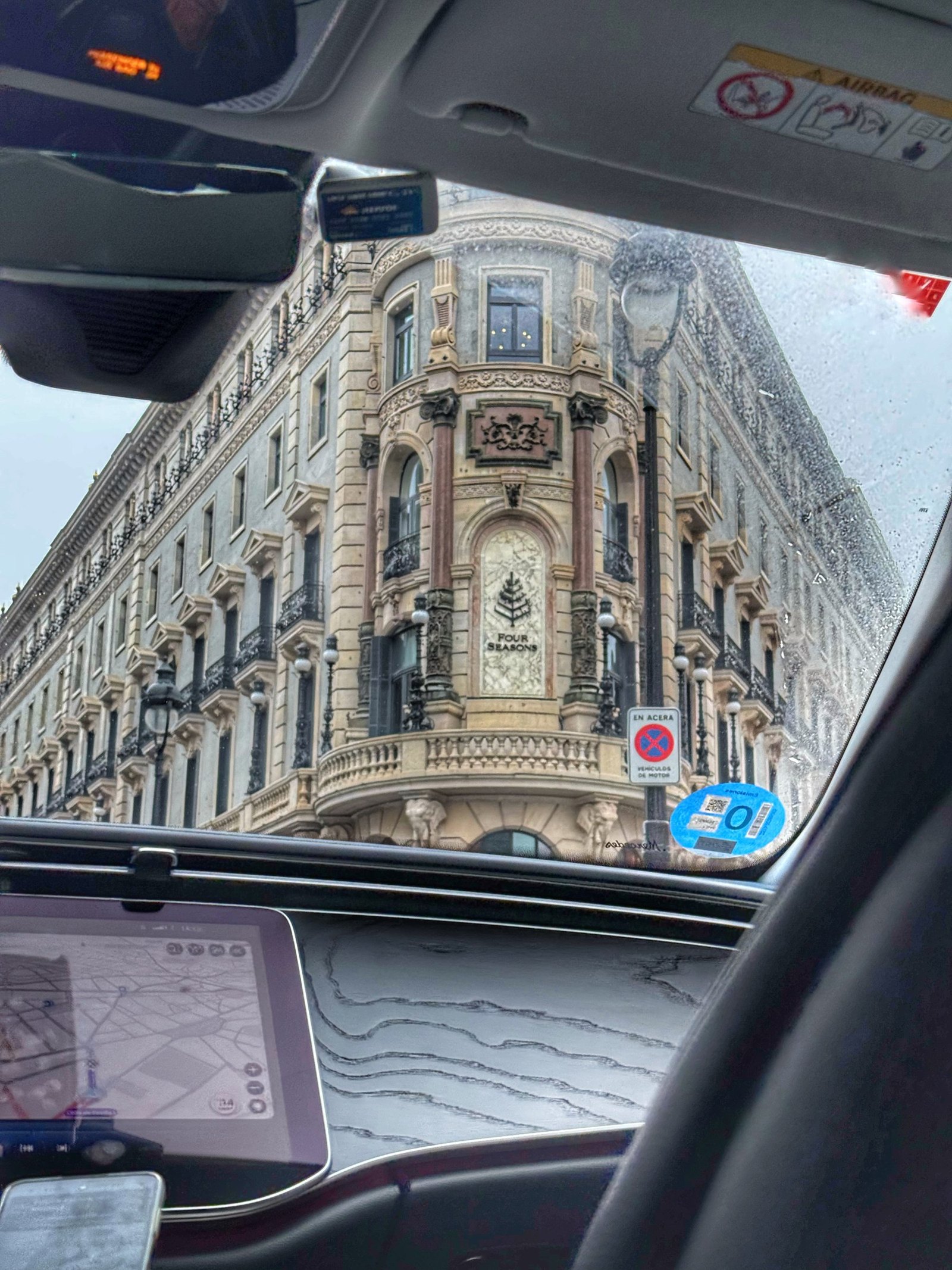 The corner facade of Four Seasons Madrid seen through a car windscreen in the rain