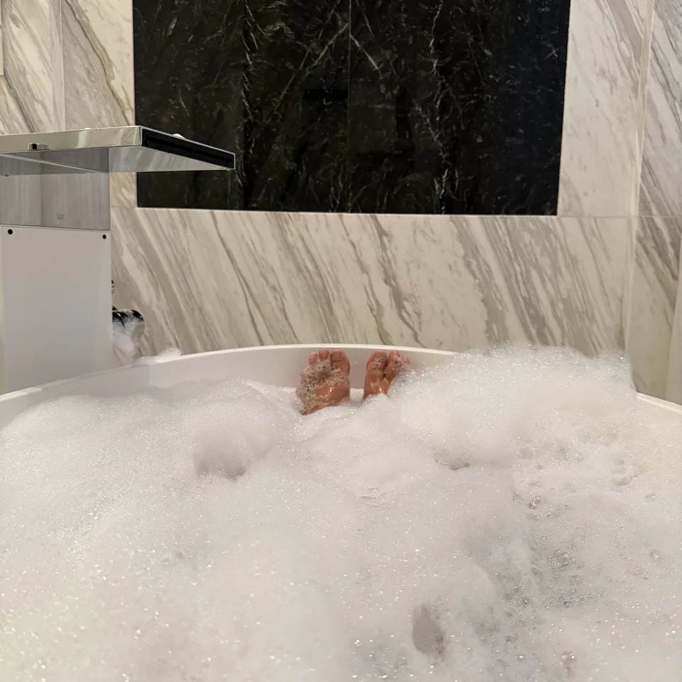 A bath filled with foam in the marble bathroom of an Executive Suite