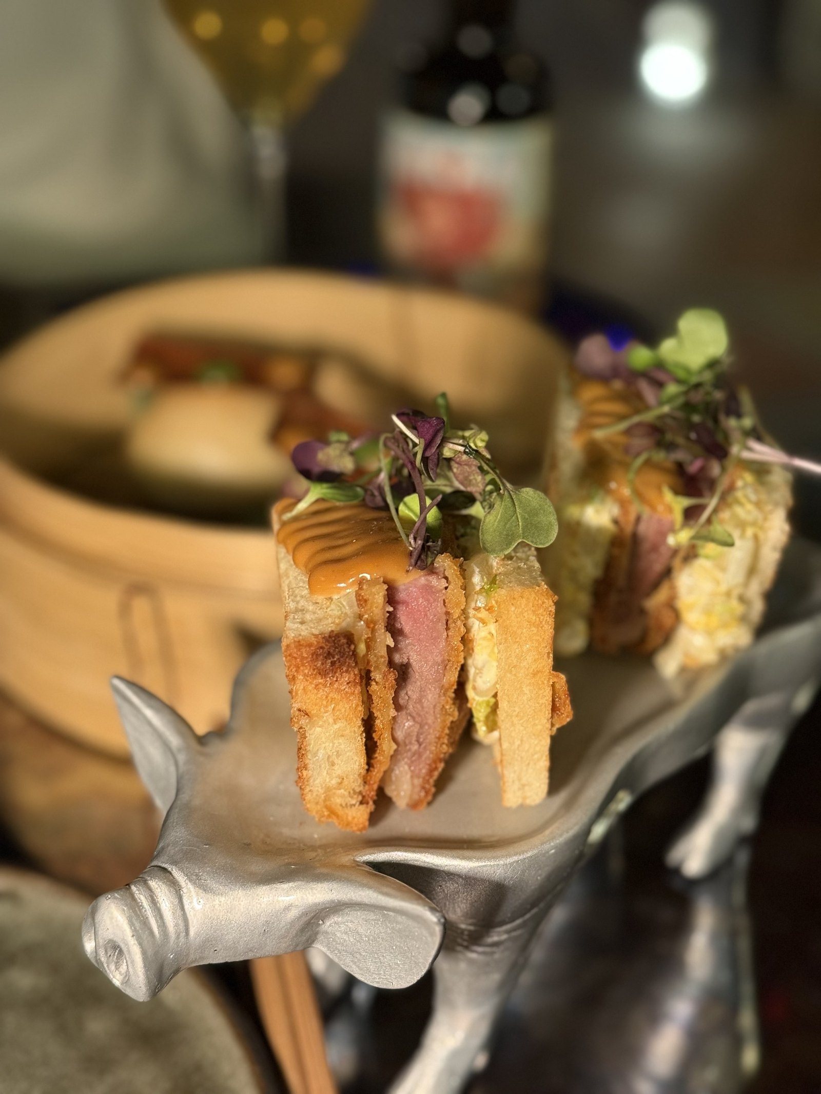 A club sandwich served on a silver stand at the rooftop brasserie