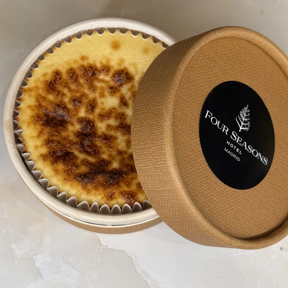 A crème brûlée with a Four Seasons Madrid lid beside it