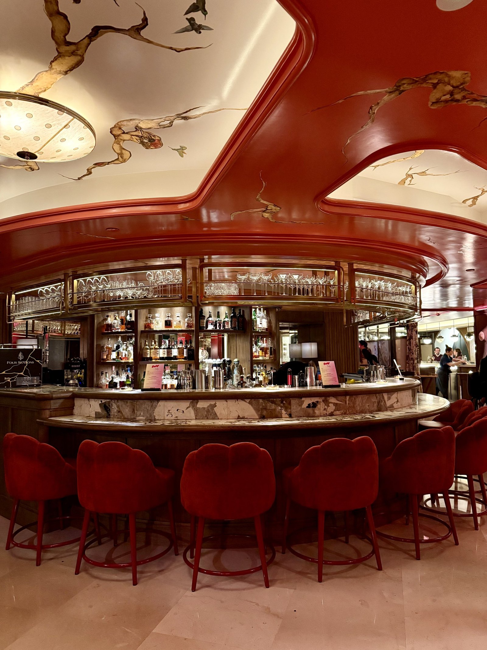 The curved red cocktail bar with red velvet stools