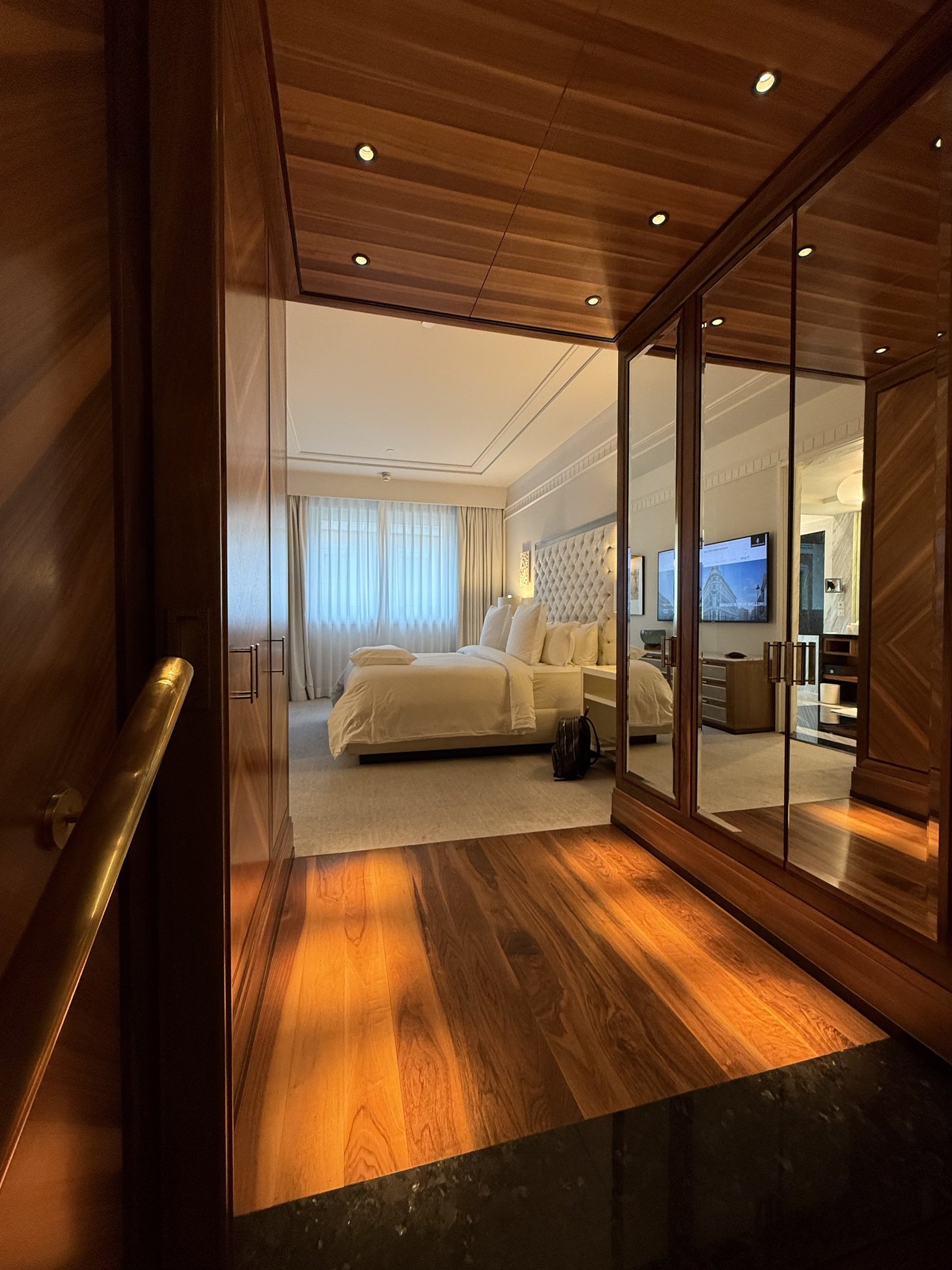 The entrance passage of an Executive Suite in walnut and mirror, looking through to the bed