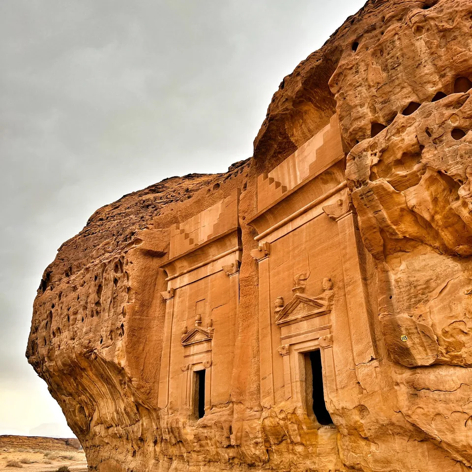 A Nabataean tomb carved into a sandstone outcrop at Hegra with a classical facade cut into the rock