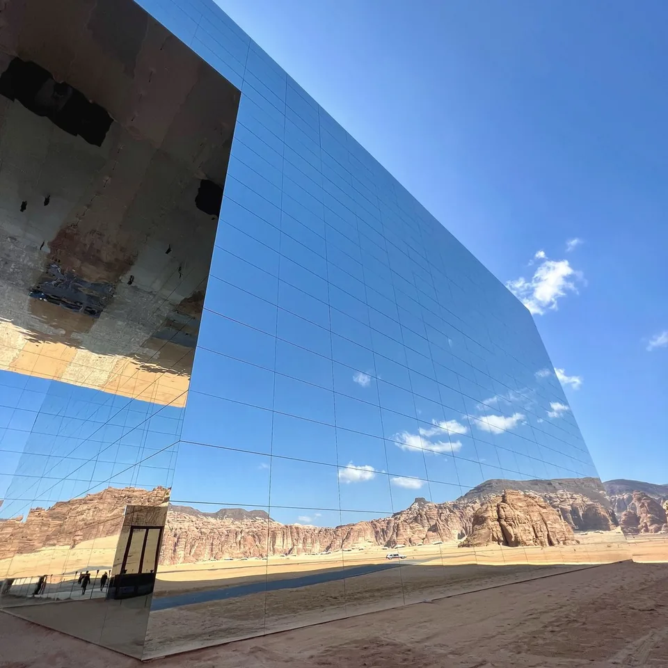 The mirrored facade of the Maraya concert hall reflecting the canyon and the sky