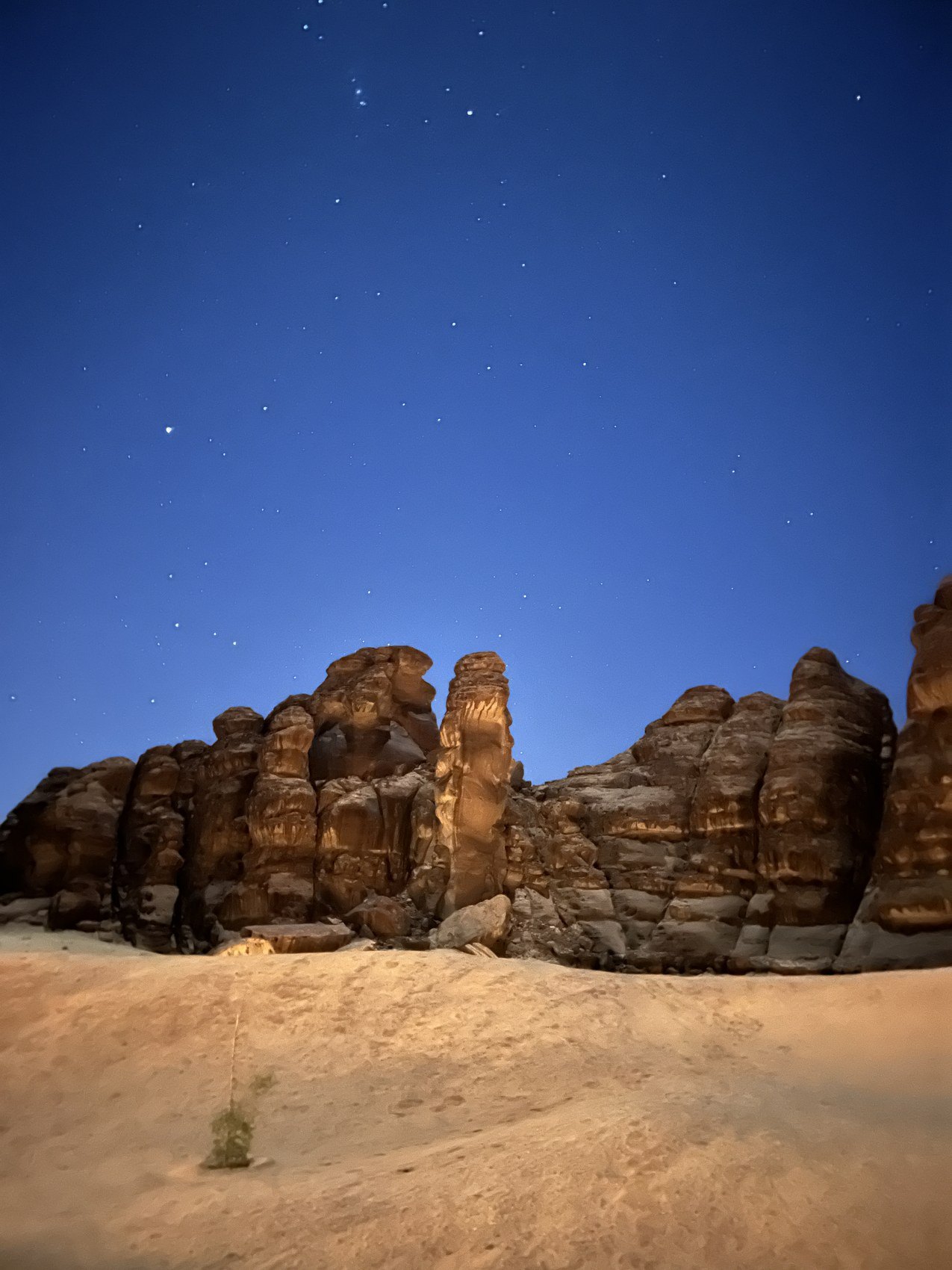 Sandstone formations silhouetted against a deep blue twilight sky with the first stars showing