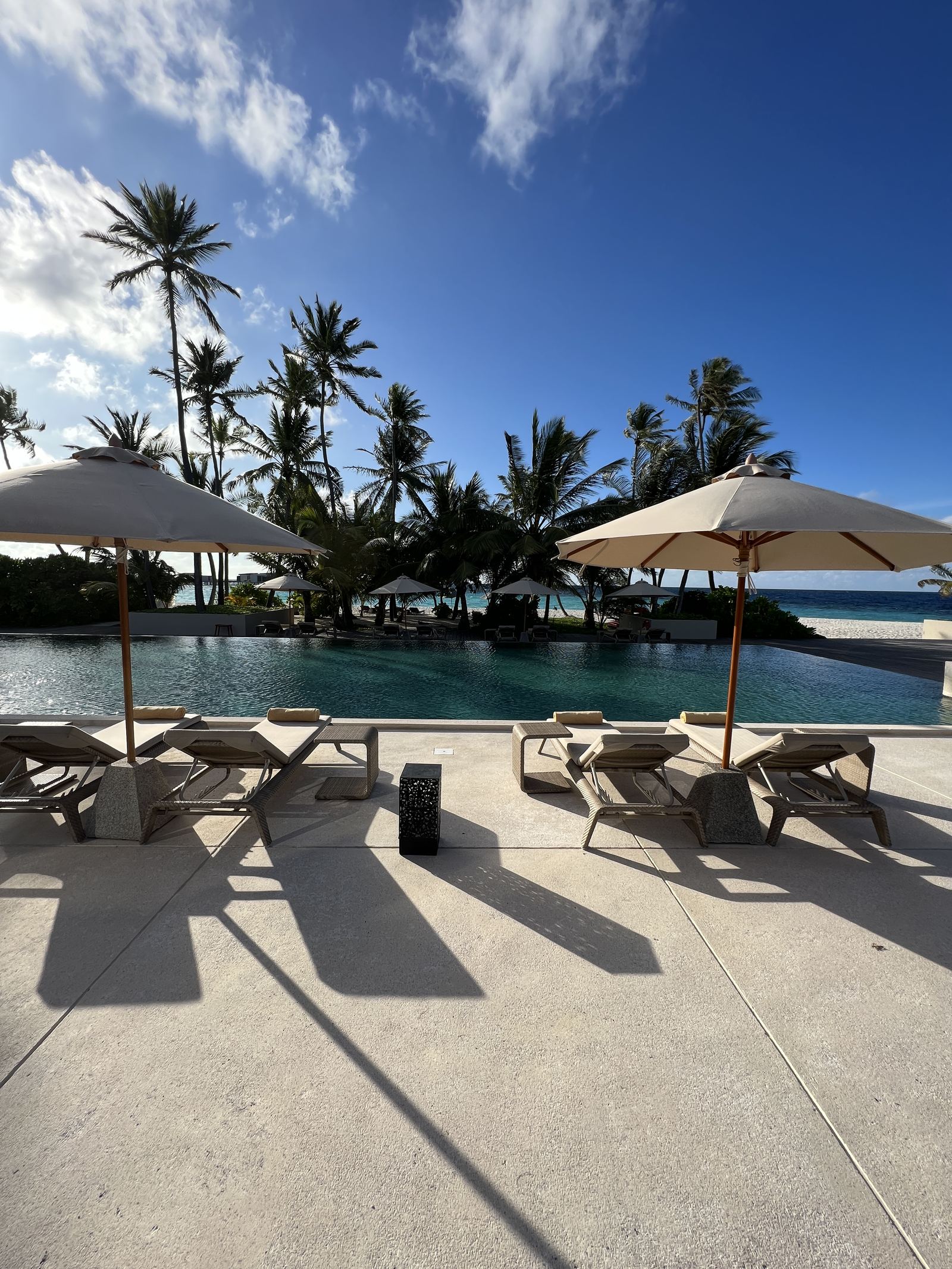 The main pool with parasols and the lagoon behind it
