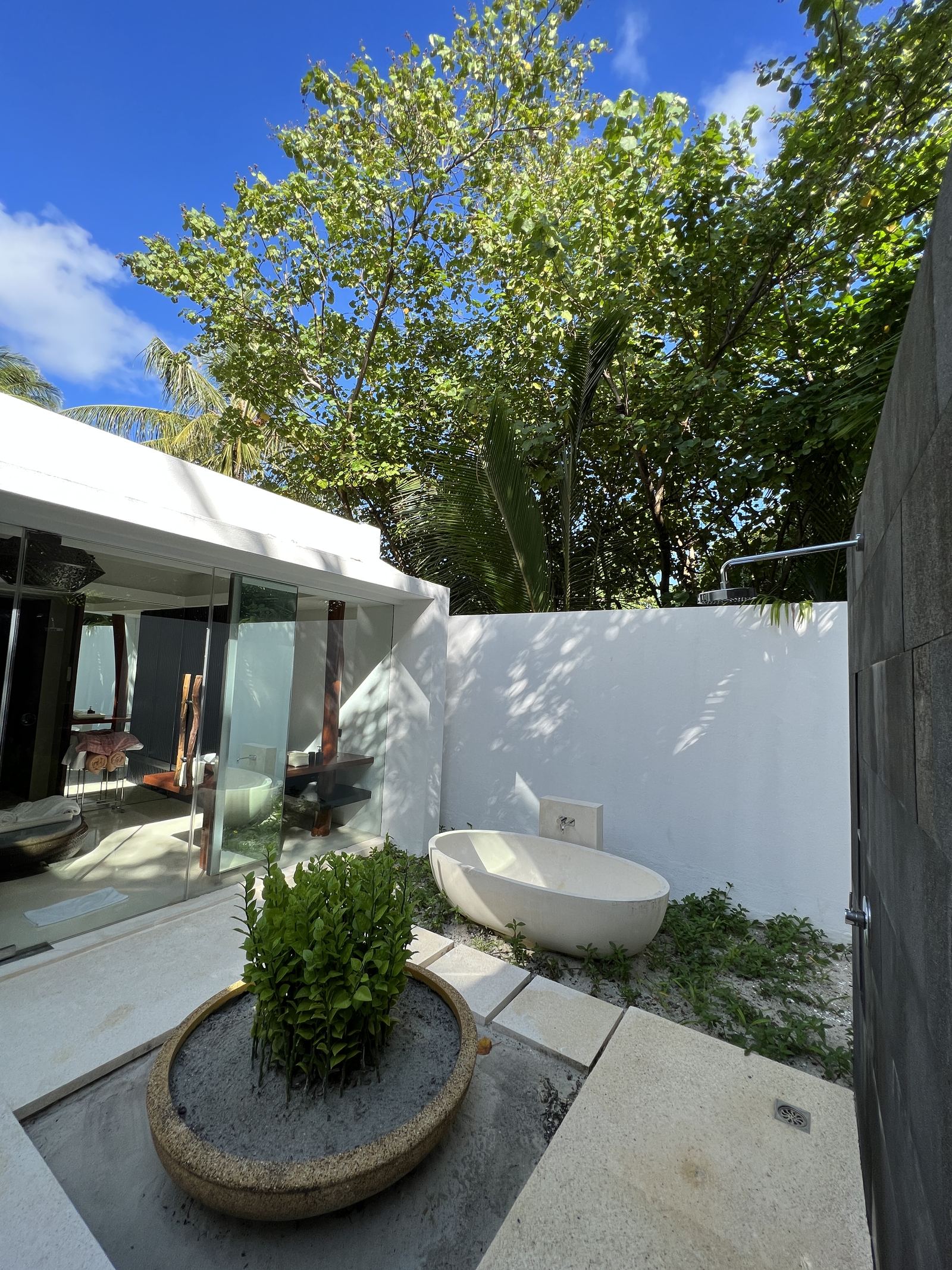 An open-air bathroom courtyard with a freestanding tub
