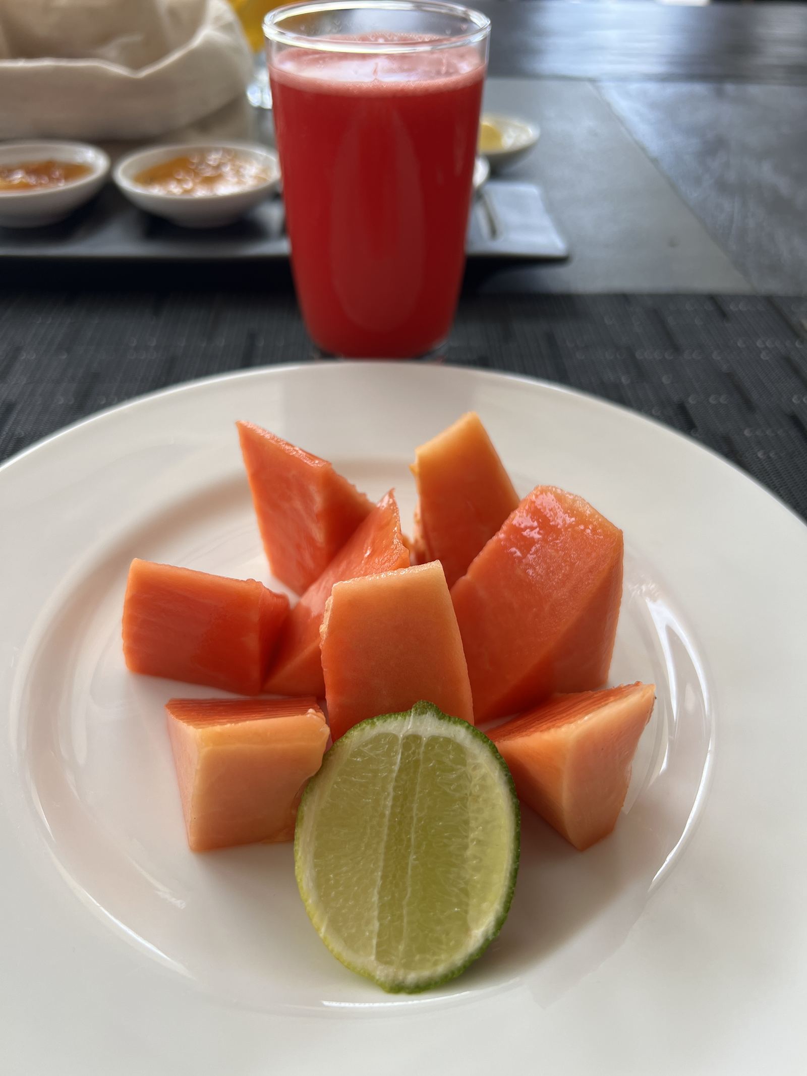 A plate of papaya with half a lime