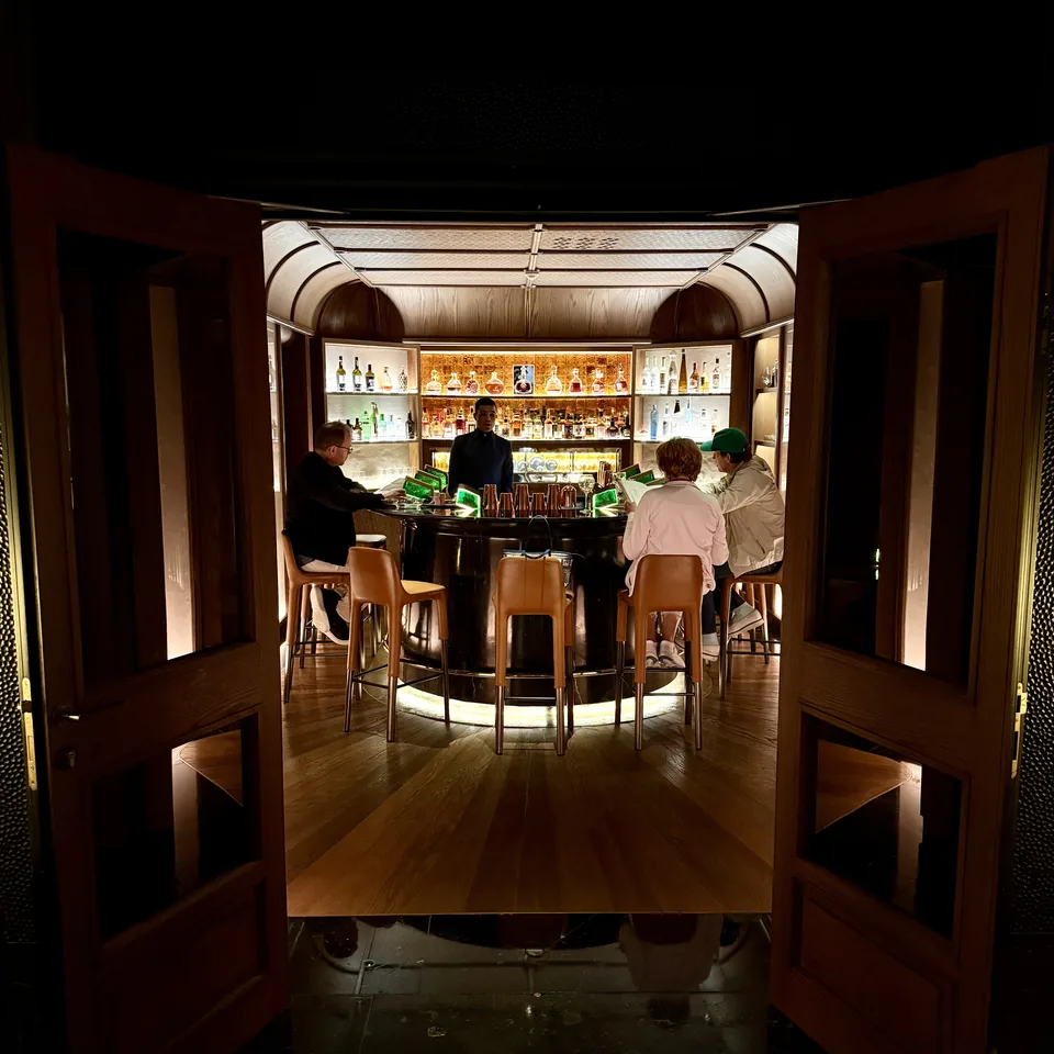 The open doors of Le Churchill, with the bar lit inside and guests on the stools