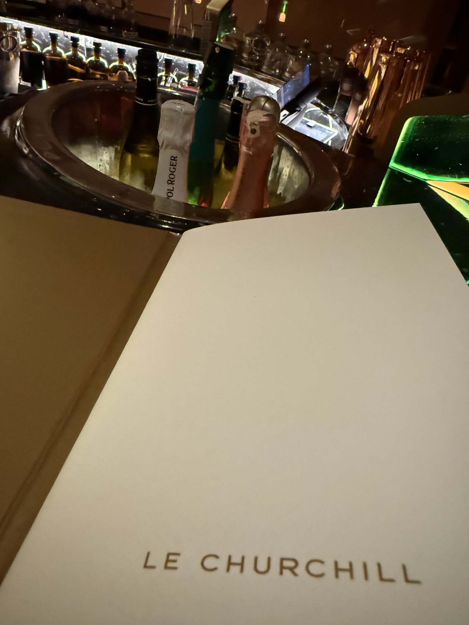 The Le Churchill menu, with a bottle in a dark bucket and a glass beside the menu