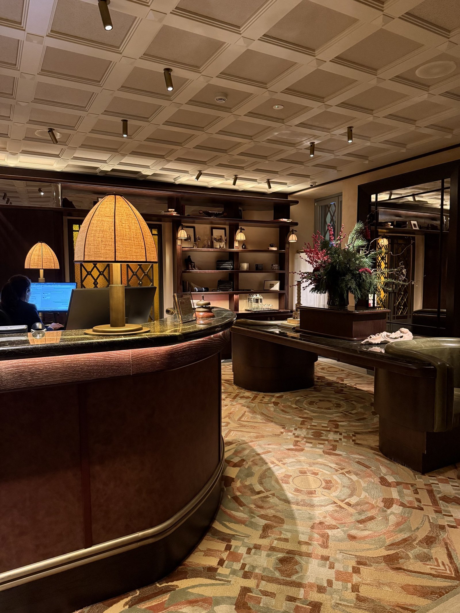 The ground floor bar with a coffered ceiling, shaded lamps and a curved counter