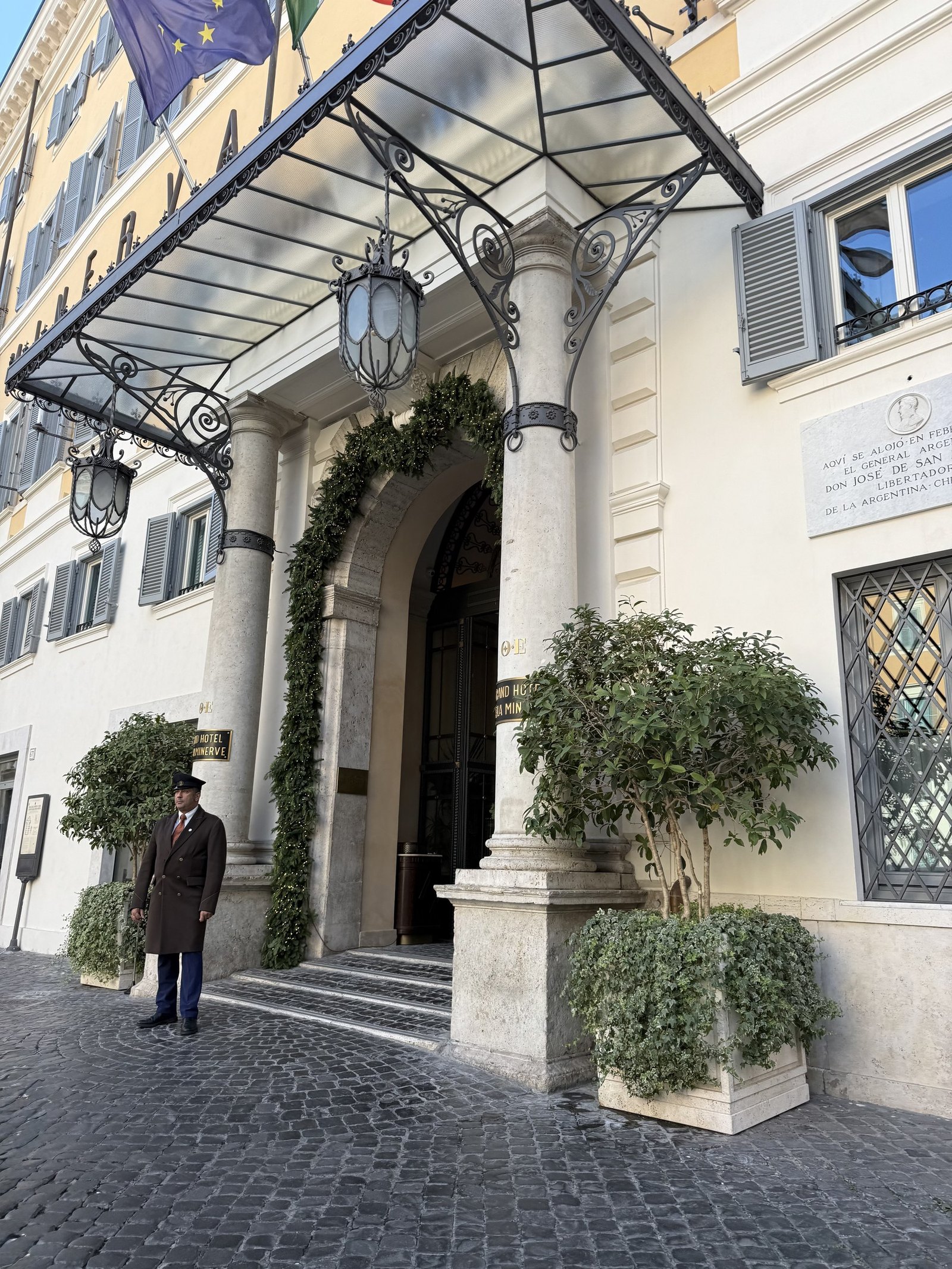 The entrance of Orient Express La Minerva on its Roman side street, with the doorman outside