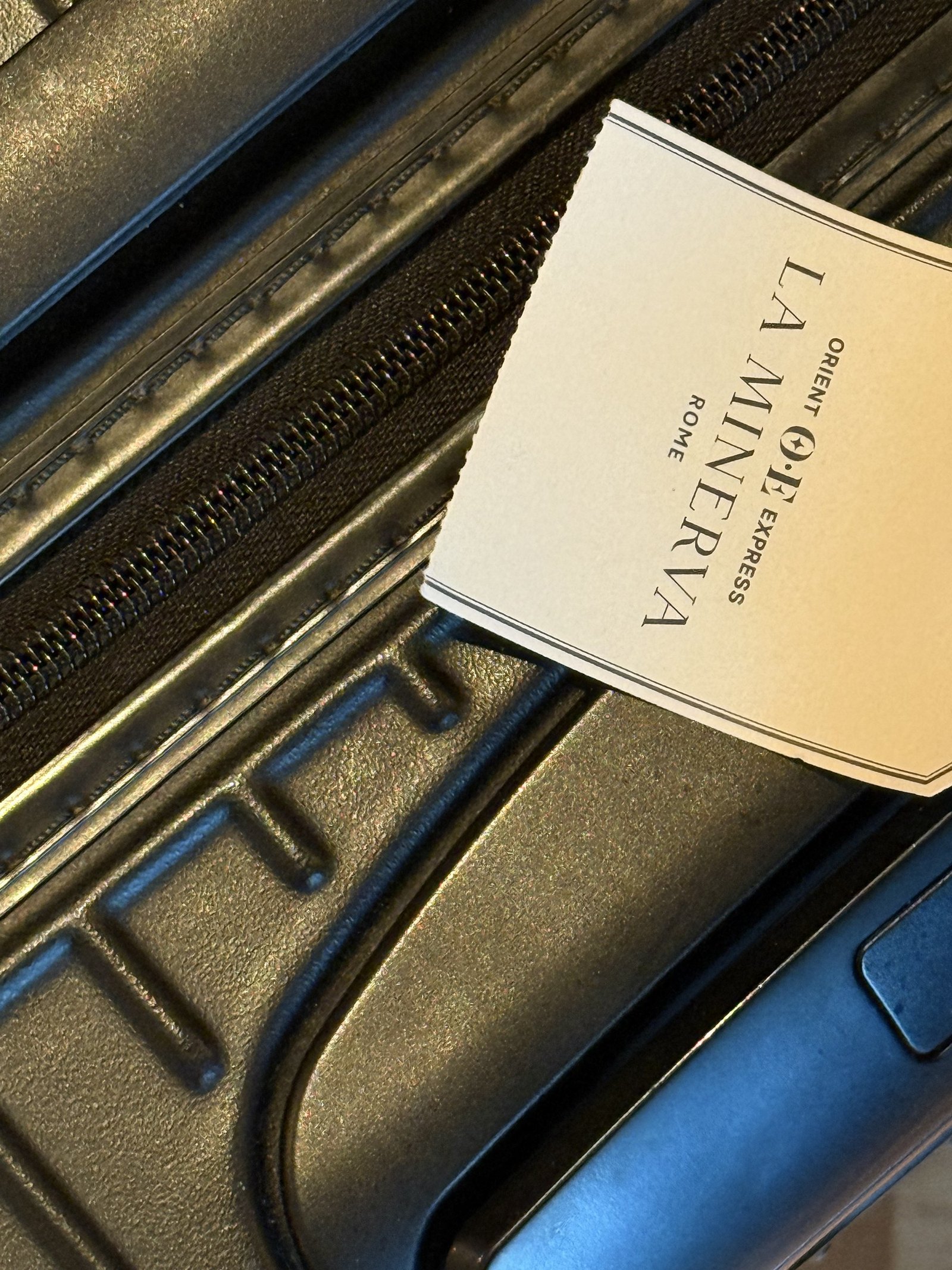 A La Minerva card tucked into the lining of an open suitcase