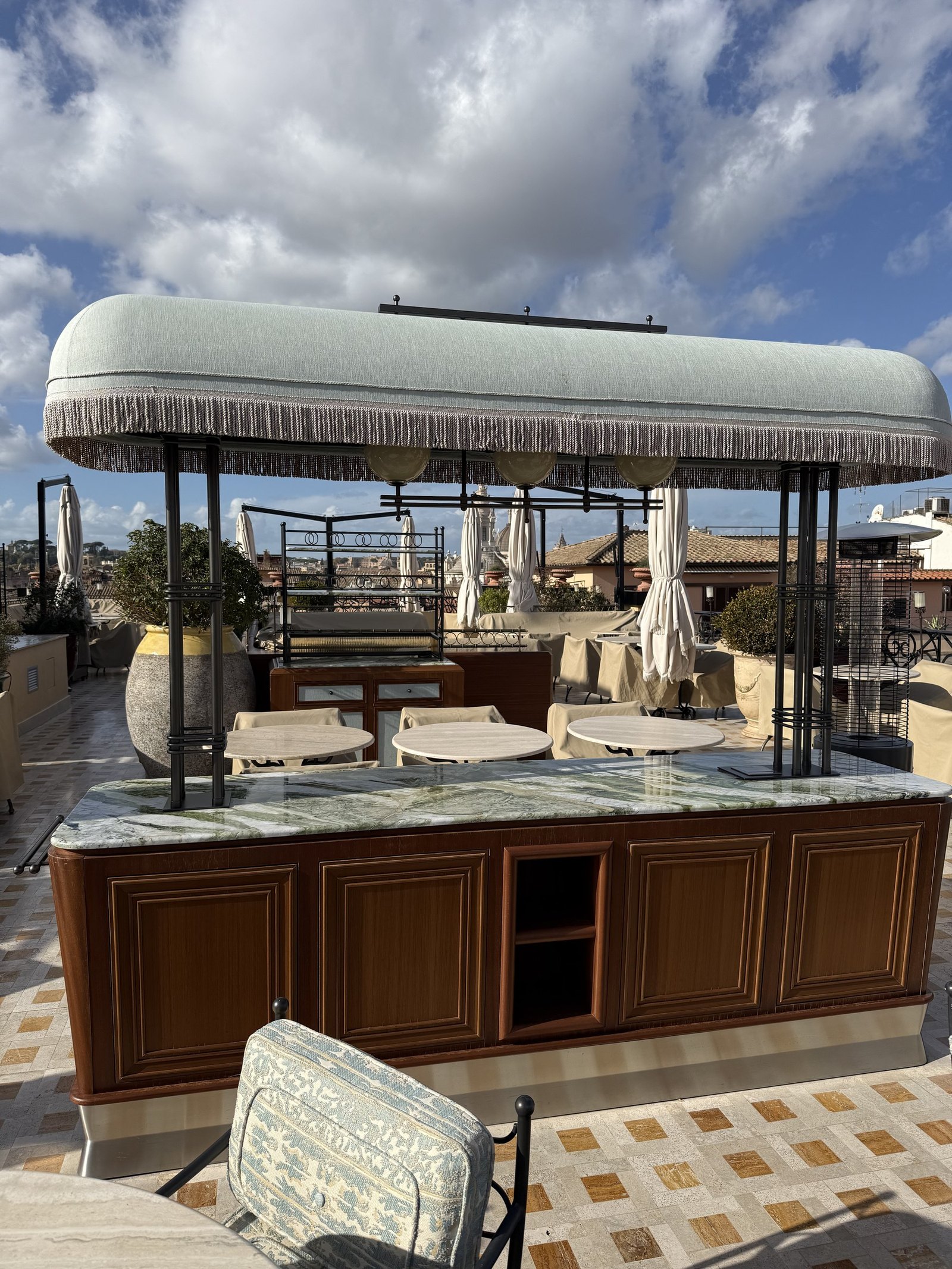 A daybed under a fringed canopy on the roof terrace