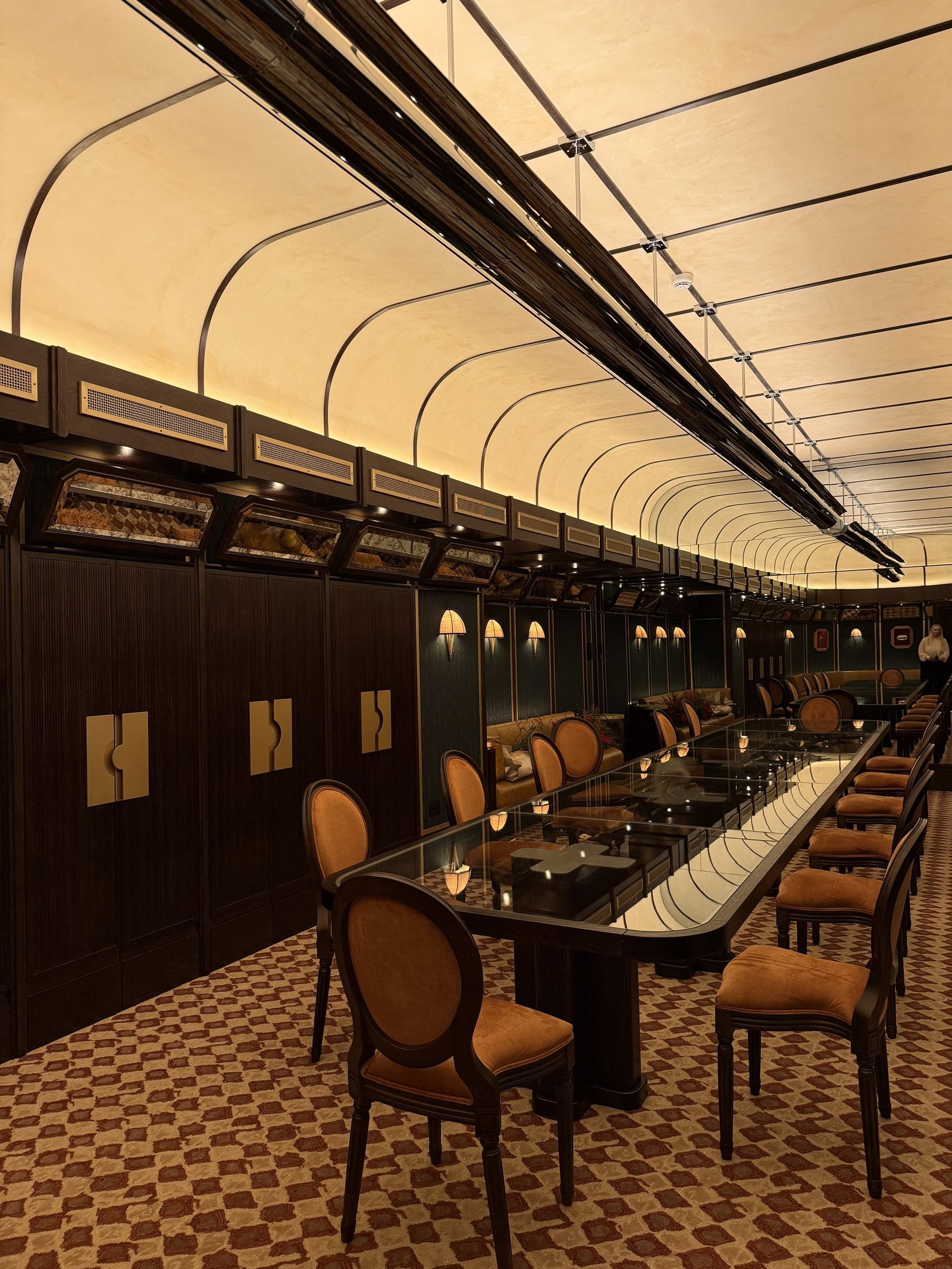 A long private dining room built with a curved ceiling and banquettes like a railway carriage