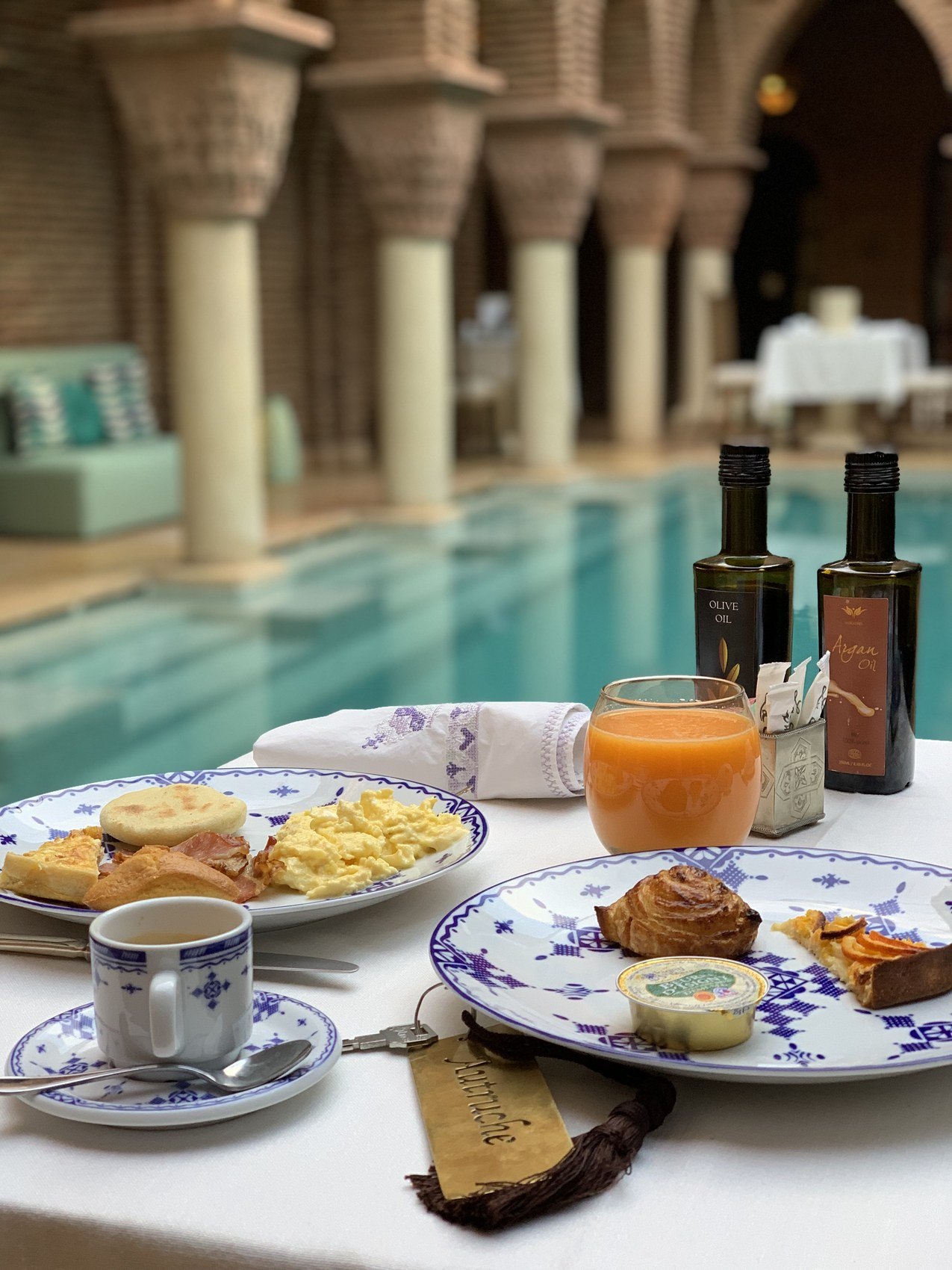 A breakfast plate with eggs and pastries, a coffee cup in blue patterned ceramic and a glass of orange juice at La Sultana