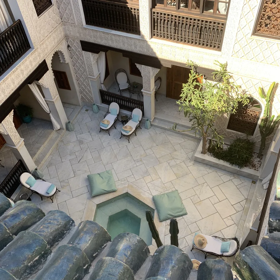 Looking down over blue tiled roofs into a white courtyard with a small plunge pool at La Sultana
