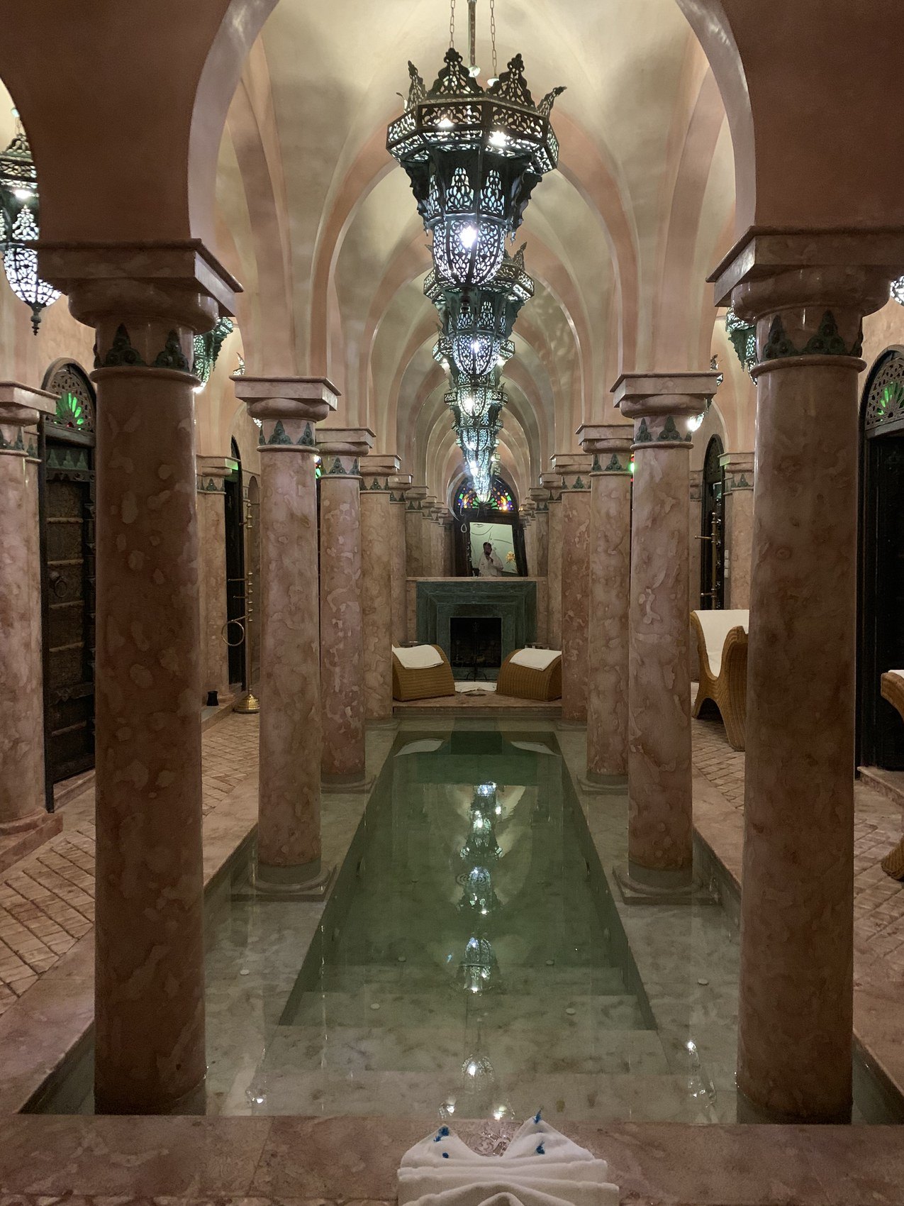 A vaulted spa at La Sultana with marble columns, a long narrow pool and a chandelier of pierced metal