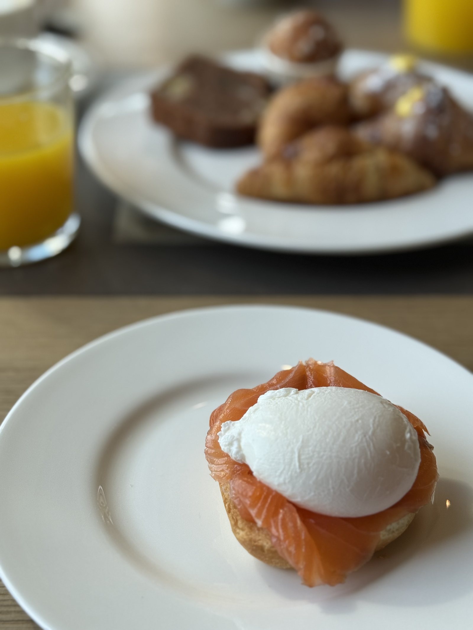 A poached egg on smoked salmon on a slice of toast, on a white plate