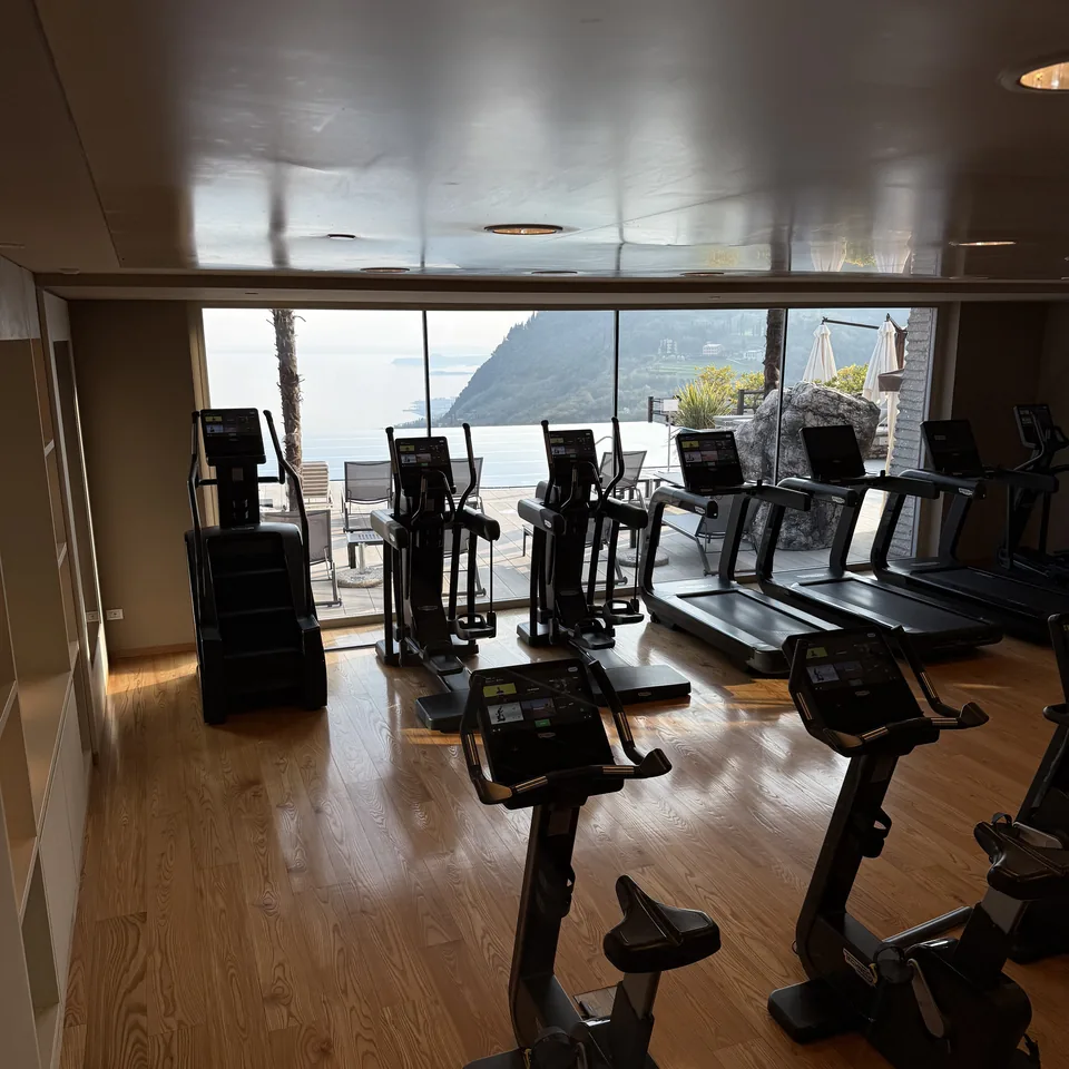 Treadmills and bikes in a gym facing a glass wall above the lake