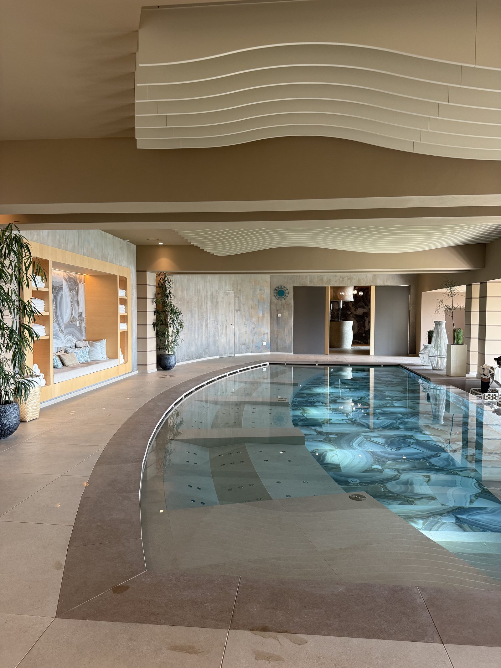 The indoor pool photographed low over the water, light coming in from the glass wall