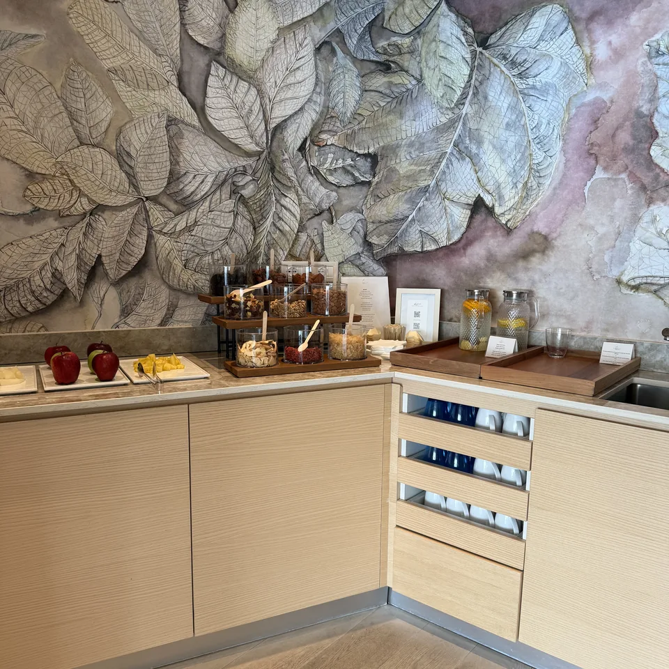 A pale timber counter with jars of herbs and teas under a wall painted with large leaves