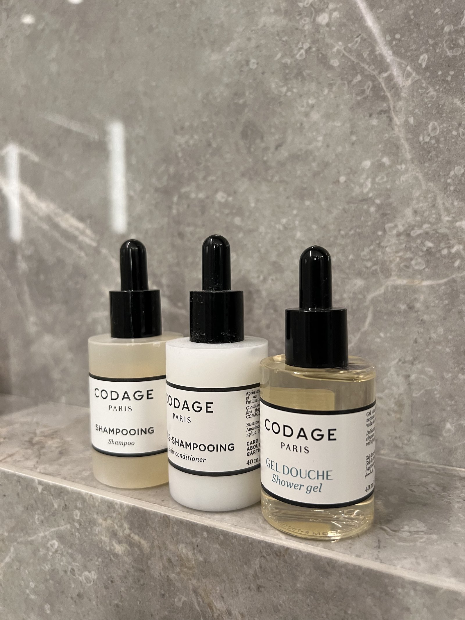 Three Codage bottles in a row on a grey marble shelf