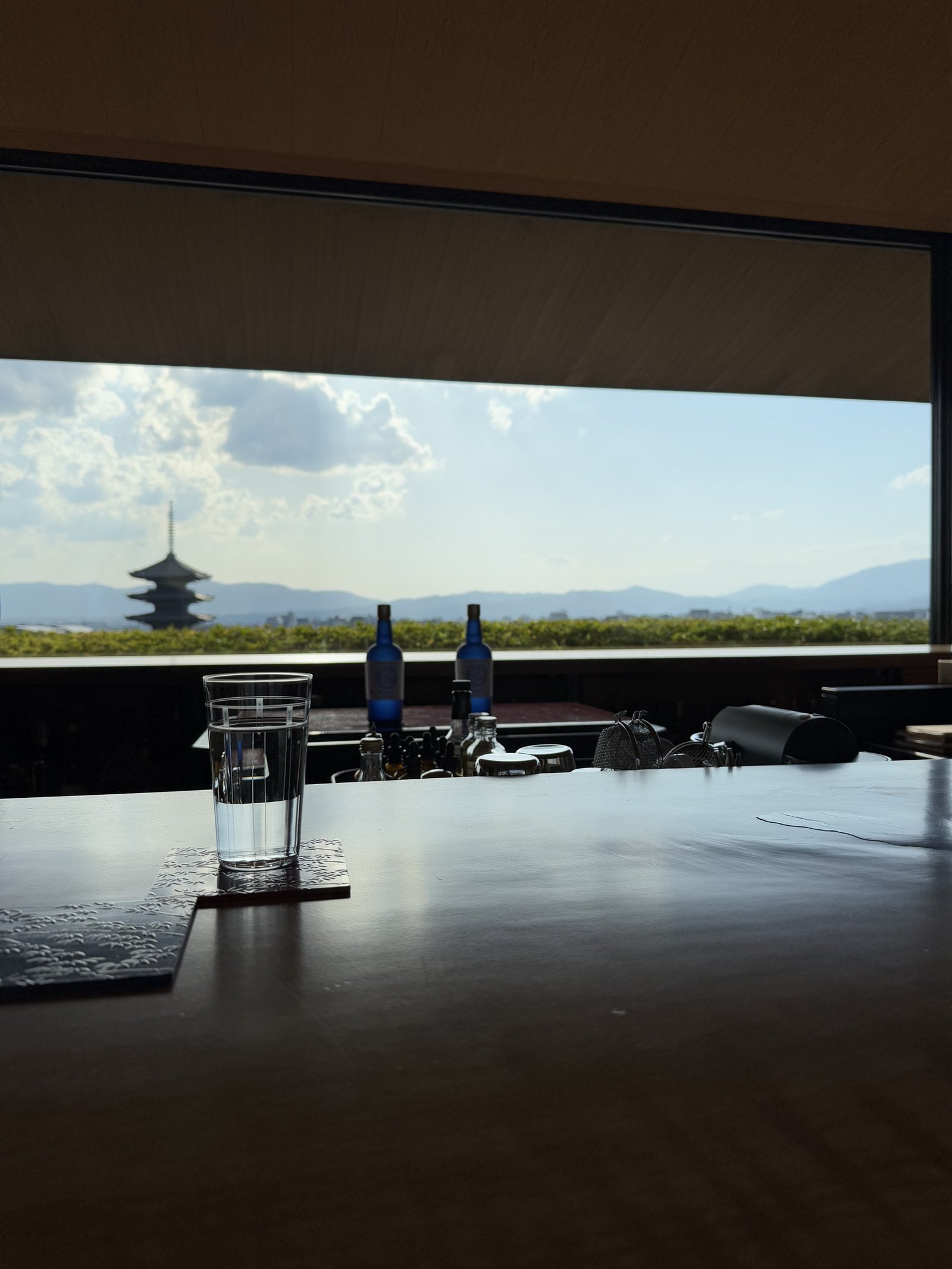 The bar counter in timber running towards a window with the pagoda beyond