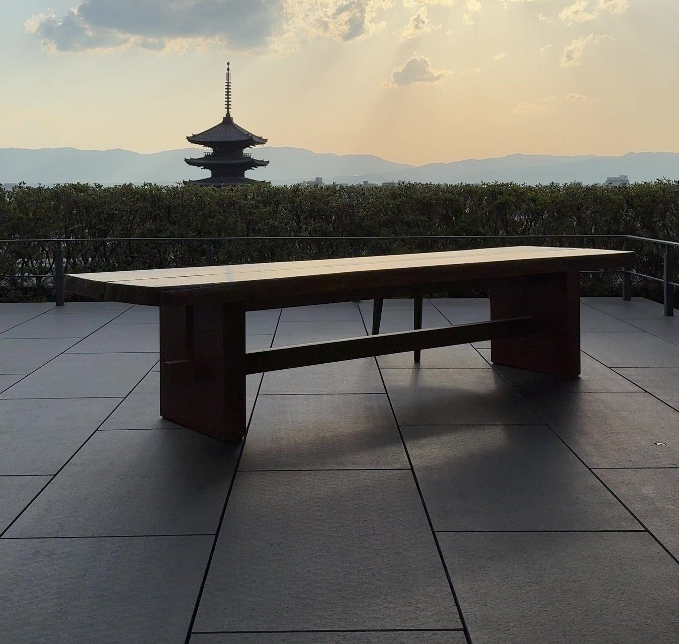 A long bench on the terrace at Park Hyatt Kyoto with the Yasaka pagoda beyond at sunset
