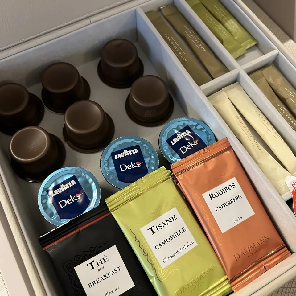 A box of tea and coffee sachets and chocolate-flavoured capsules in a compartmented tray