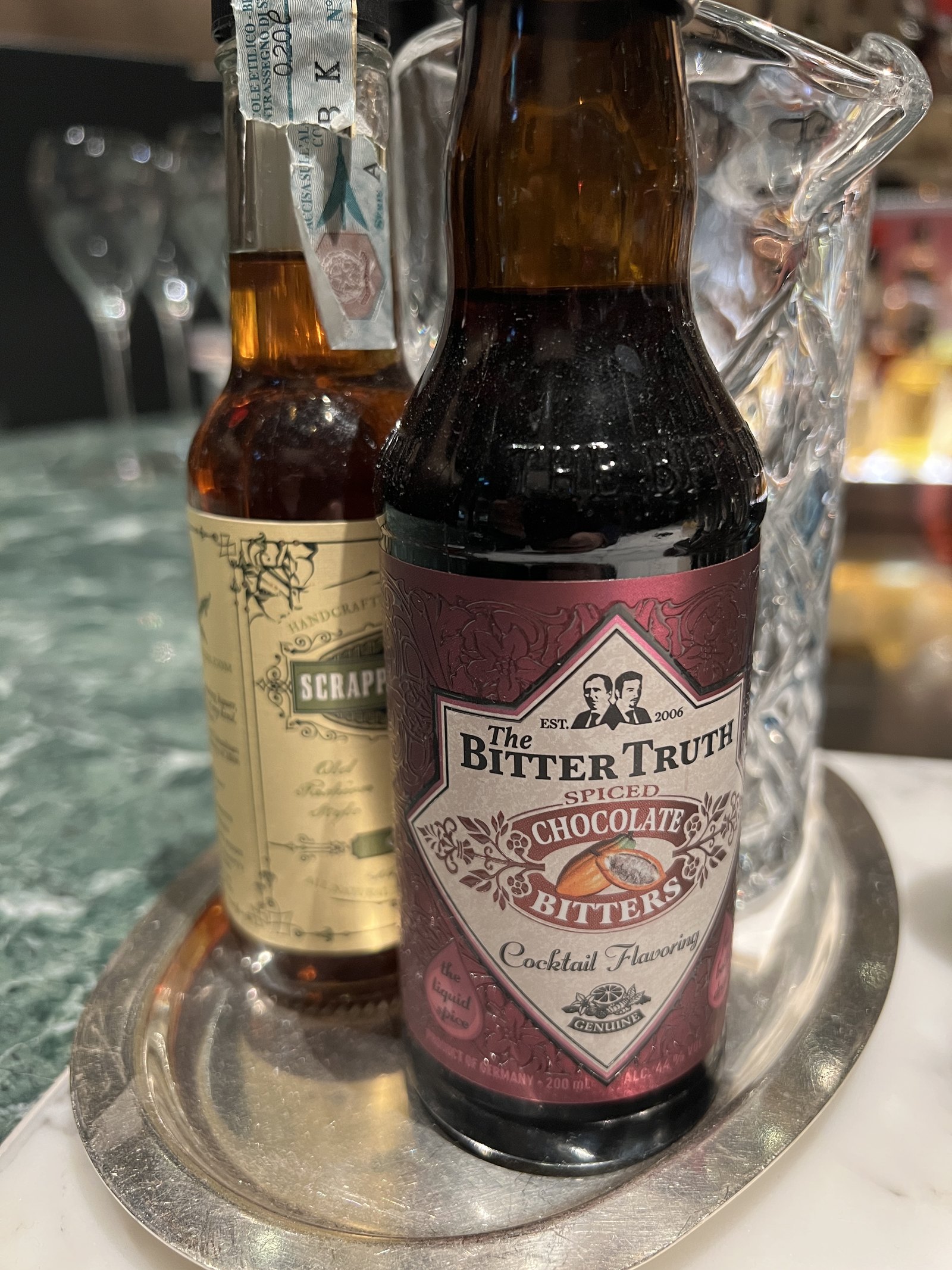 Two bottles of bitters on a silver tray