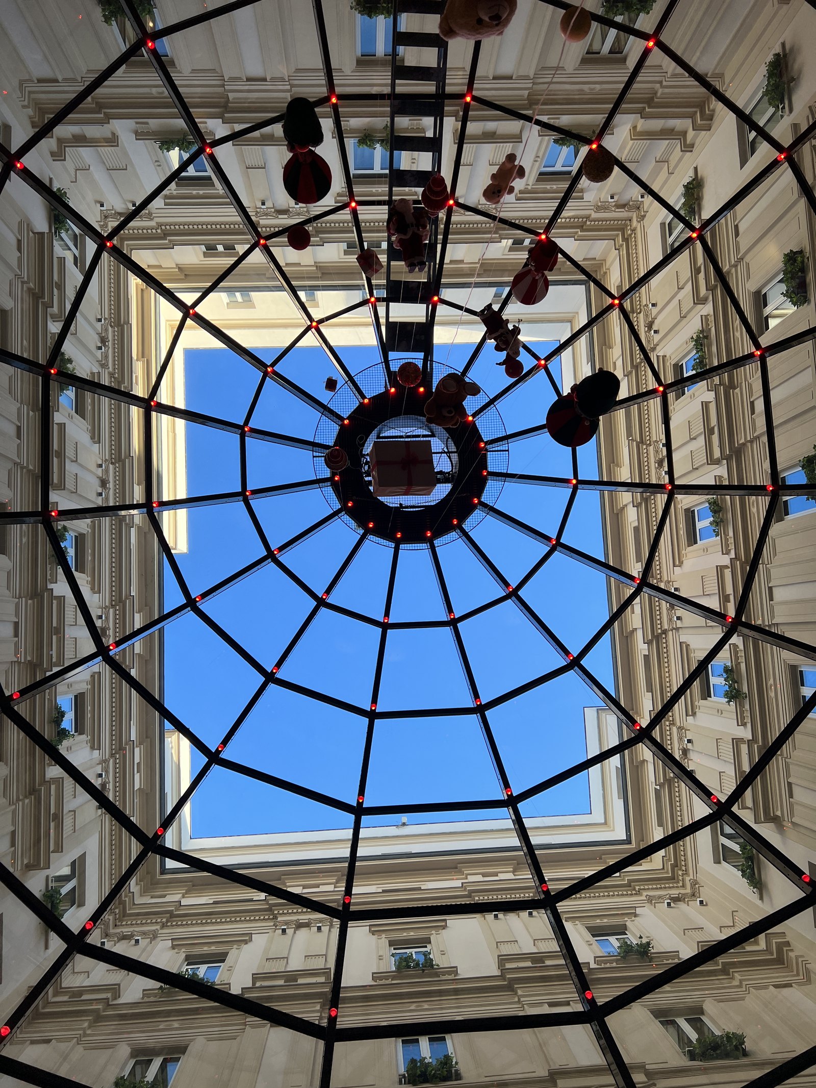 Looking up through the glass cupola, with the iron frame and the building beyond