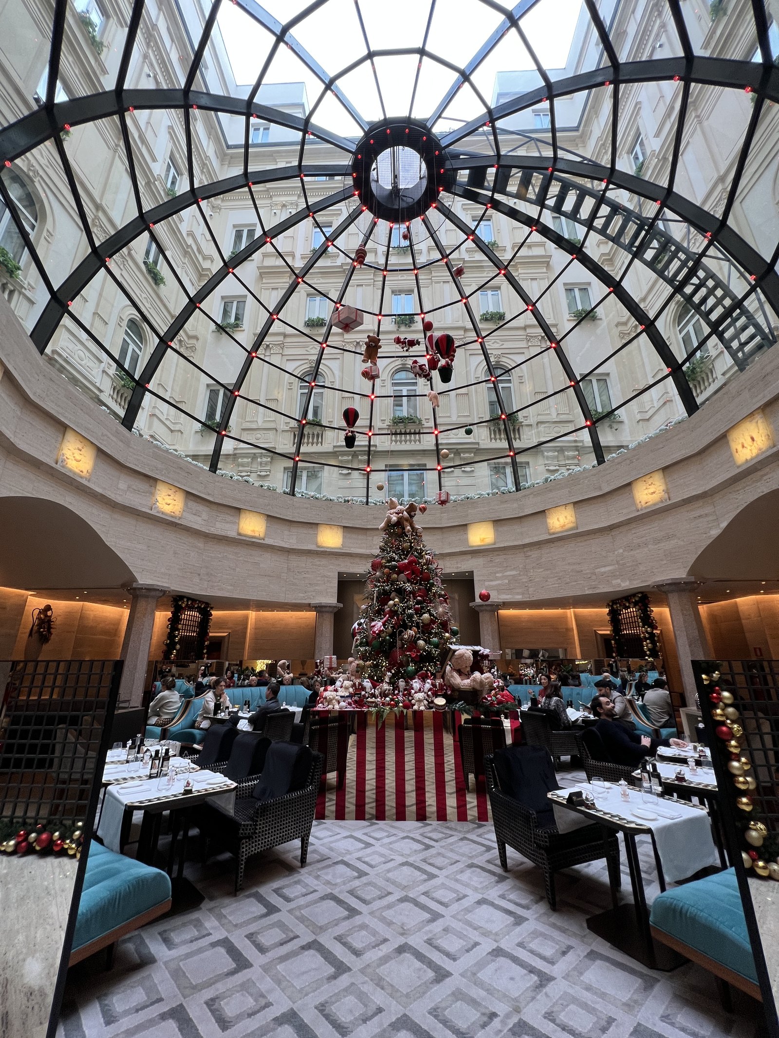 The glass cupola over the restaurant with a Christmas tree beneath it and diners at tables
