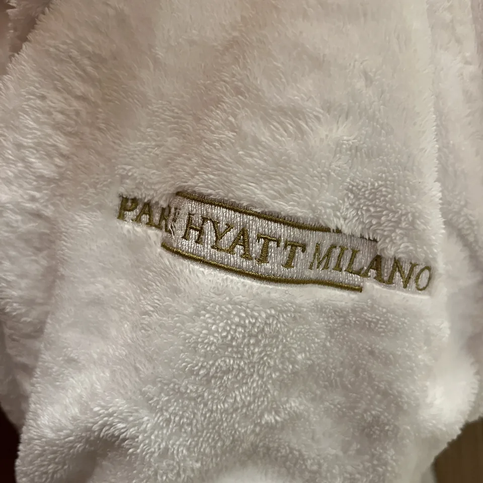 A white terry robe with PARK HYATT MILANO embroidered in gold