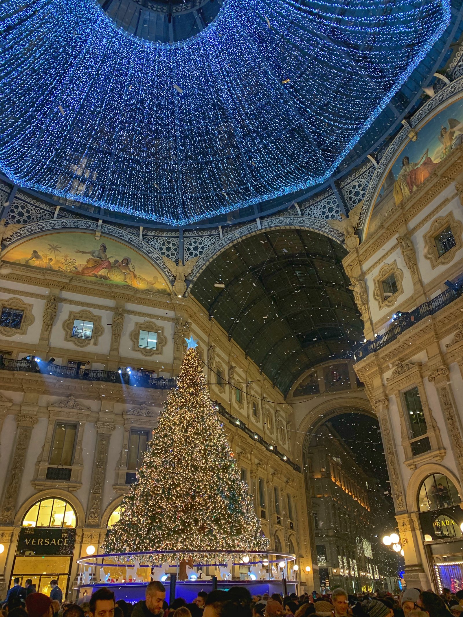 The Galleria Vittorio Emanuele II with a large blue-lit Christmas tree under the glass vault